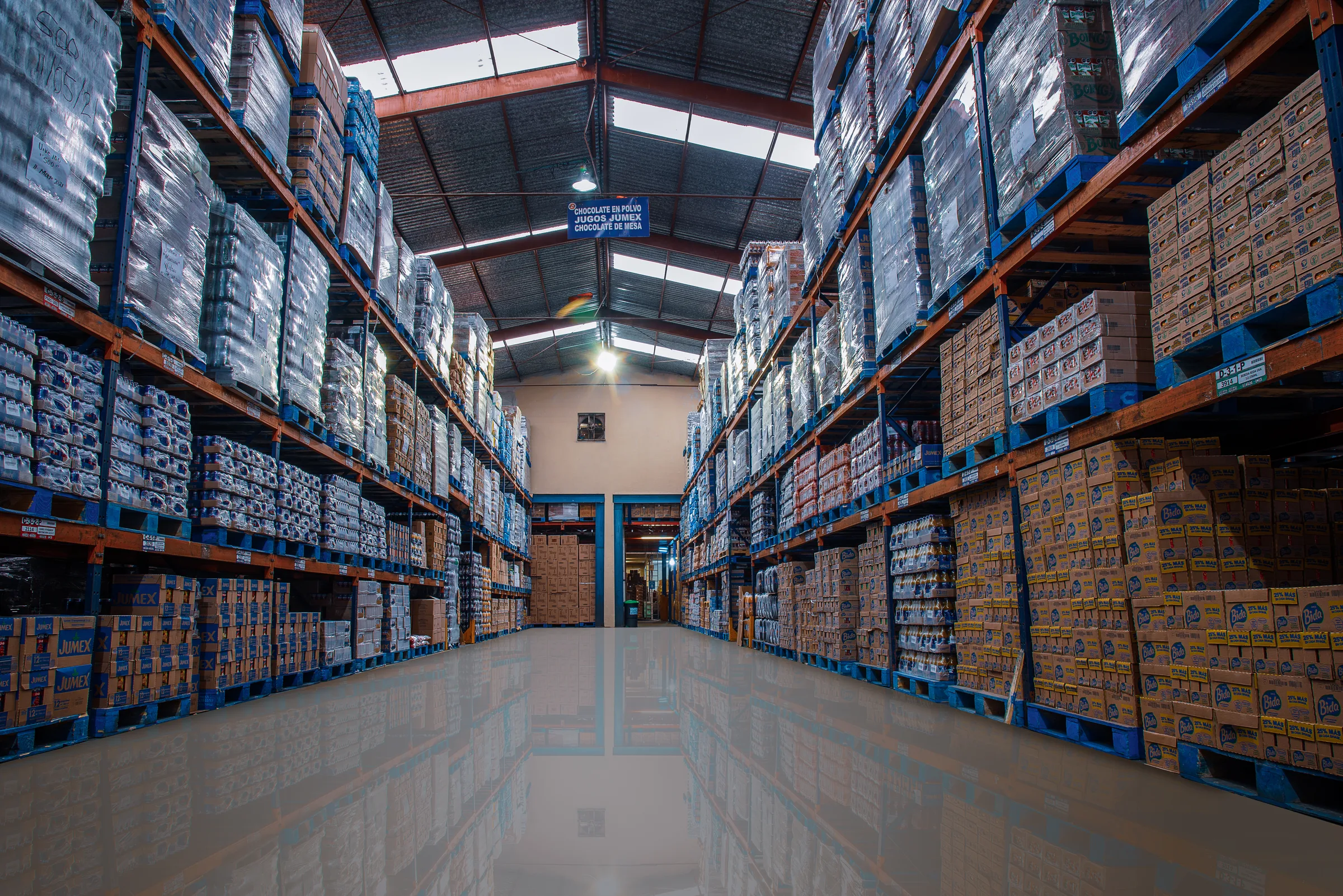 Pasillo del almacén de CEVISUR con racks de abarrotes a ambos lados